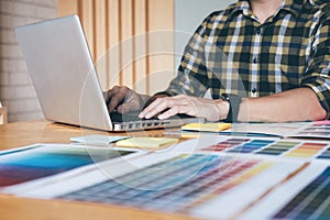 Young creative Graphic designer using graphics tablet to choosing Color swatch samples chart for selection coloring with work too