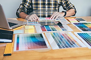 Young creative Graphic designer using graphics tablet to choosing Color swatch samples chart for selection coloring with work too