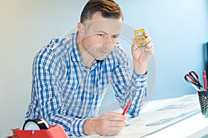 Young creative male engineer making project on drawing board