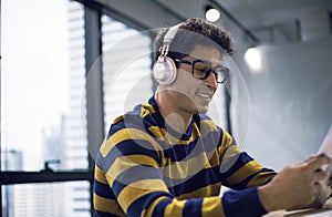 Young  creative man looking job on smart phone on desk in the offices.