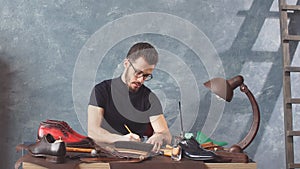 Young creative shoemaker inventing stylish shoes