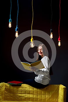 Young creative student with colorful lamps and books