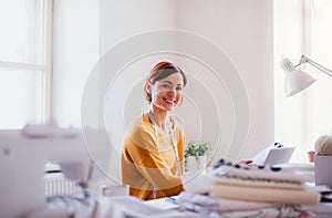 Young creative woman in a studio, startup of small tailoring business.