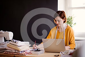 Young creative woman in a studio, startup of small tailoring business.