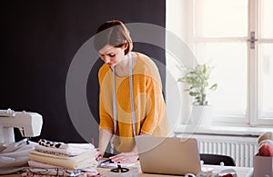 Young creative woman in a studio, startup of small tailoring business.