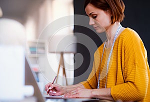 Young creative woman in a studio, startup of small tailoring business.