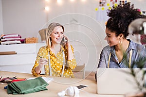 Young creative women with laptop in studio, startup business.