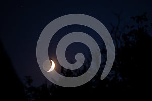 young crescent moon with the dark side in sight