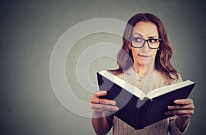 Curious nerd woman reading book photo