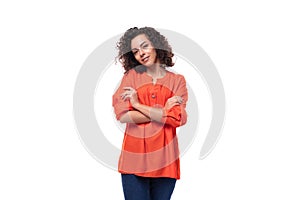 young curly brunette lady dressed in a stylish bright orange blouse on a white background with copy space