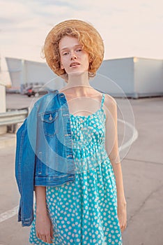 Young curly redhead woman in straw hat