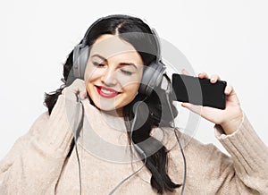 Young curvy brunette woman in headphones listening to music