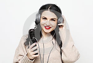 Young curvy brunette woman in headphones listening to music