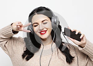 Young curvy brunette woman in headphones listening to music