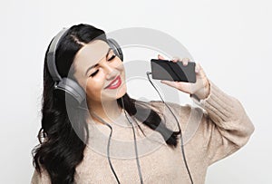 Young curvy brunette woman in headphones listening to music