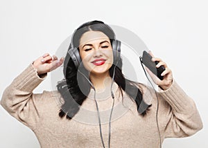 Young curvy brunette woman in headphones listening to music