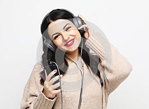 Young curvy brunette woman in headphones listening to music