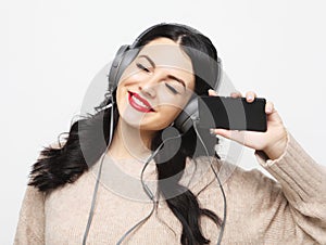 Young curvy brunette woman in headphones listening to music