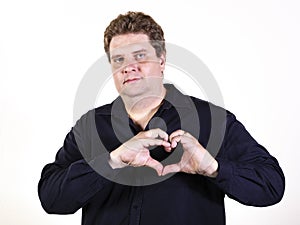 Young curvy man posing in a white background isolated smiling and showing a heart shape with hands