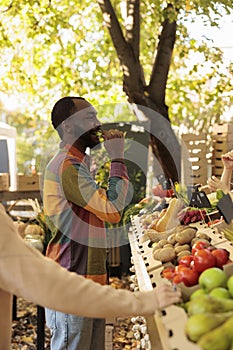 Young customer buying fruits and vegetables from local vendor