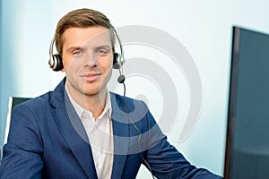 Young Customer Support Phone Operator with Headset at his Working Place in Office.
