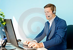 Young Customer Support Phone Operator with Headset Working in the Office.