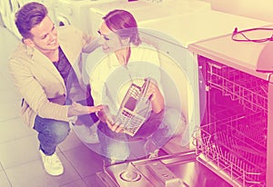 Young customers choosing new dish washing machine