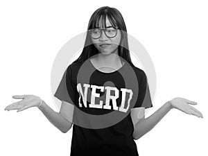 Young cute Asian nerd teenage girl shrugging shoulders