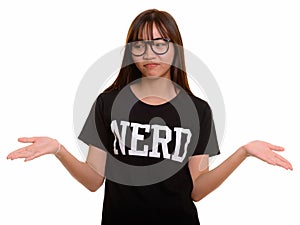 Young cute Asian nerd teenage girl shrugging shoulders