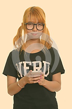 Young cute Asian nerd woman using mobile phone