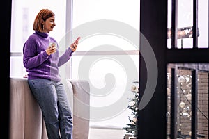 Young cute beaming girl in bright socks watching a movie online