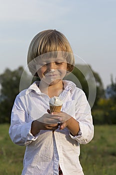 Young cute blond boy eating a tasty ice cream