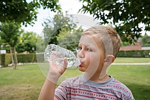 Young cute boy drinking water