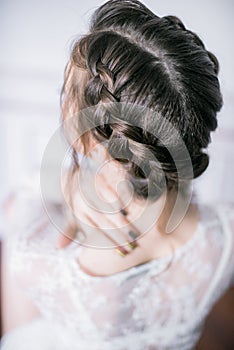 Young cute bride with beautiful hair in the morning at home in white negligee