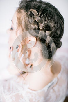 Young cute bride with beautiful hair in the morning at home in white negligee