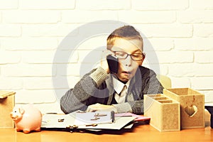 Young cute businessboy on white brick wall background, copy space