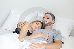 Young cute couple hug and sleep together in bed