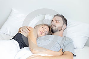 Young cute couple hug and sleep together in bed