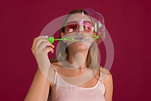 Young cute girl blows soap bubbles, isolated