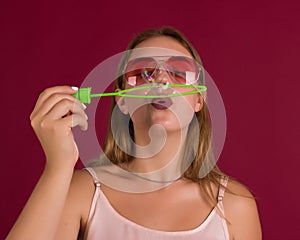 Young cute girl blows soap bubbles, isolated