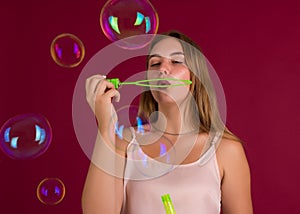 Young cute girl blows soap bubbles, isolated