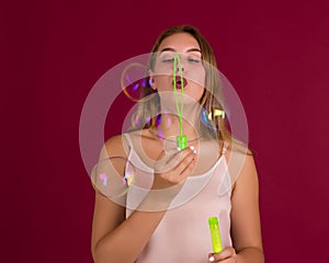 Young cute girl blows soap bubbles, isolated