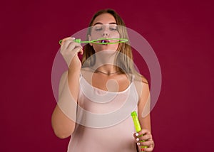 Young cute girl blows soap bubbles, isolated