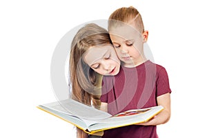 Young cute girl and boy are looking at the yellow book