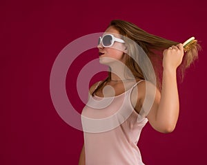 Young cute girl with hair brush, studio