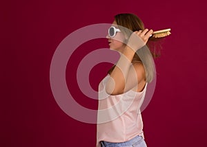 Young cute girl with hairbrush, isolated