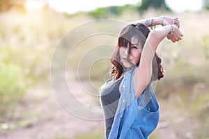 Young and cute girl having a happy time and enoying amoung grass field in nature