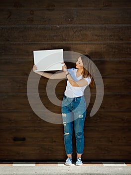 Young cute girl, holding empty sign board.