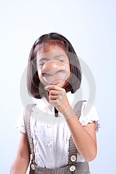 Young cute girl holding magnifying