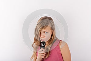 Young cute girl holding a microphone singing karaoke